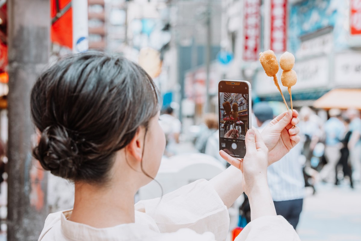 スマートフォンで地図を確認しながら街を歩く人
