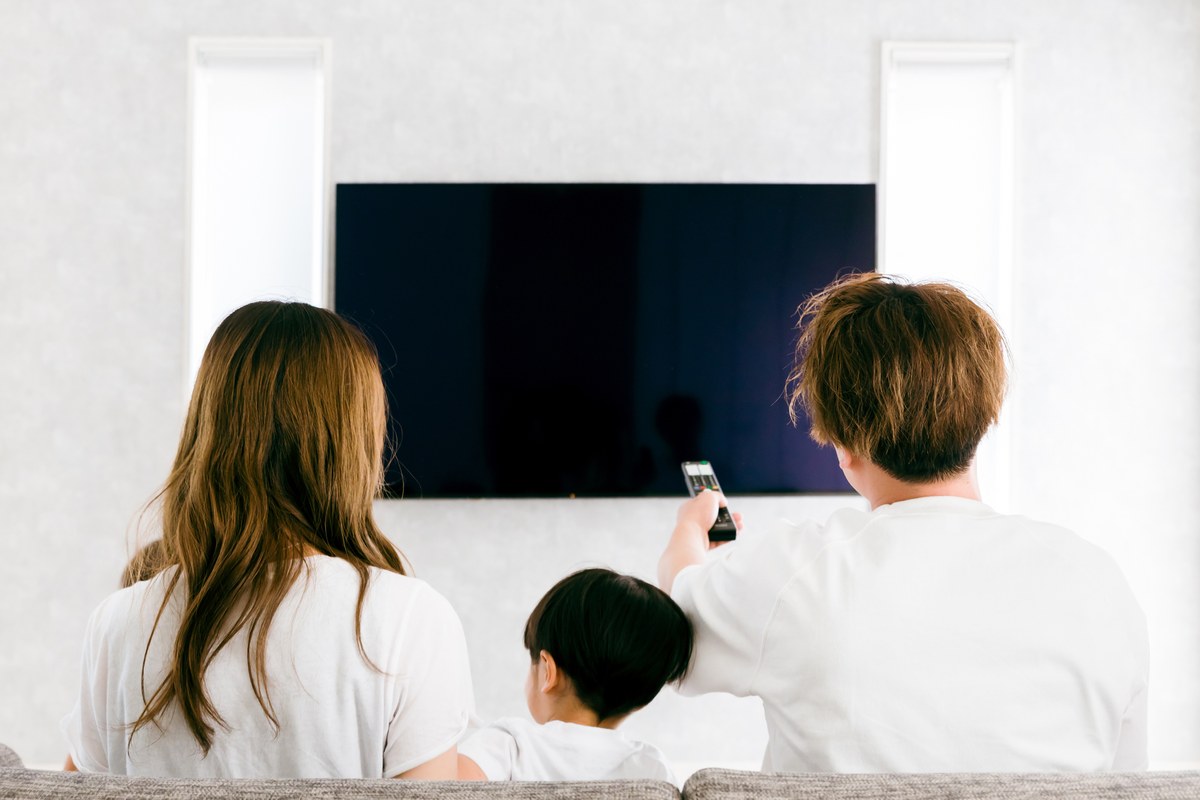 家族がリビングでテレビとインターネットを楽しむ様子