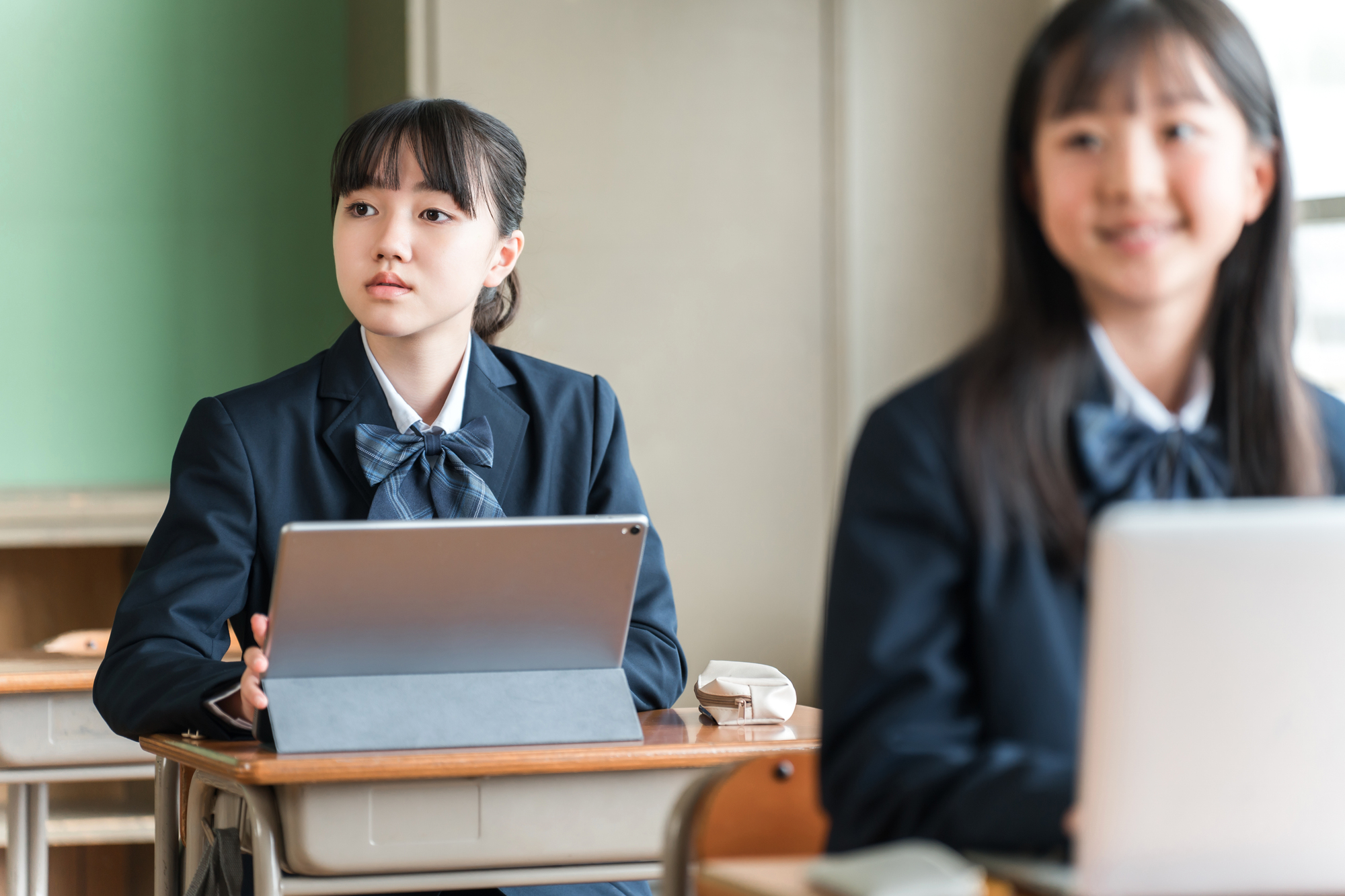 教室でタブレットを使って学習する女子生徒のイメージ
